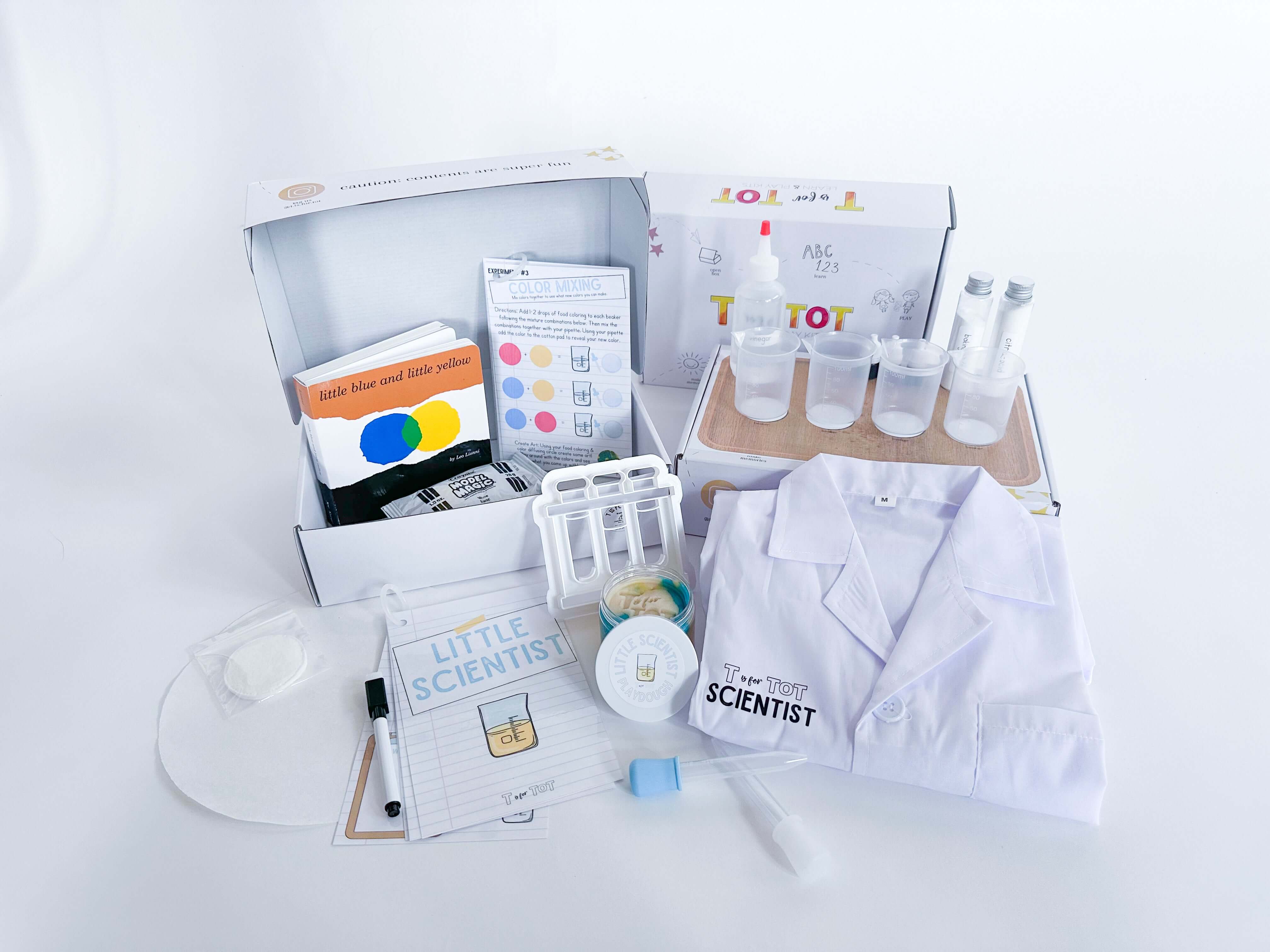 Little Scientist play and learn kit for kids with experiments, beakers, pipettes, food coloring, and other science tools. Includes a lab coat, experiment guide with dry erase marker, and art supplies for creative activities. Comes with 